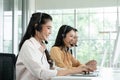 Group of Asian employee work in telemarketing customer service teams. Young operator woman working with headset smiling Royalty Free Stock Photo