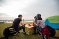 A group of Asian friends drinking coffee and spending time making a picnic in the summer holidays.They are happy and have fun on