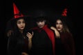 Group of asian friends in spooky costume of witch and vampire posing at halloween celebration party in nightclub