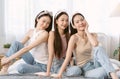 Group of Asian Girl friends feeling happy posing together sitting on bed. Smiling korean blogger influencer girls skincare, Royalty Free Stock Photo