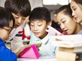 Group of asian primary school pupil playing game using tablet Royalty Free Stock Photo