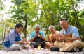 A group of Asian senior people enjoy painting cactus pots and recreational activity or therapy outdoors together at an elderly