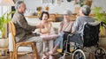 Group Asian seniors friends are sitting in the living room of a home together, enjoying talking together. Royalty Free Stock Photo