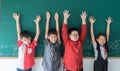 Group of Asian student hands up on blackboard
