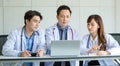 Group of Asian successful professional male and female doctors in white lab coat uniform with stethoscope sitting meeting together Royalty Free Stock Photo