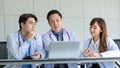 Group of Asian successful professional male and female doctors in white lab coat uniform with stethoscope sitting meeting together Royalty Free Stock Photo