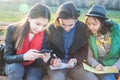Group of Asian teenage students schoolchildren sitting on a bench in the park and preparing exams Royalty Free Stock Photo