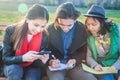 Group of Asian teenage students schoolchildren sitting on a bench in the park and preparing exams Royalty Free Stock Photo