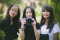 Group of asian teenager relaxing in garden with dslr camera in hand Royalty Free Stock Photo