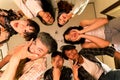 a group of Asian teenagers forming a circle and looking down with funny faces in an old room Royalty Free Stock Photo