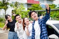 Group of Asian teenagers taking a selfie together smiling happily.