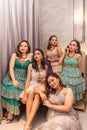 a group of Asian women in luxurious dresses are waiting for dinner in a hotel ballroom