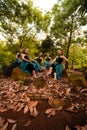 A Group of Asian women takes a vacation to the forest while wearing a green skirt and sitting on a rock Royalty Free Stock Photo