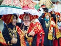 Group of Asian women wearing traditional minangkabau ethnic costume in wedding ceremony carrying offering goods on their head.