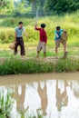 Group of Asian young boys enjoy to fishing using harpoon and they cheer up also stay near pond and rice field Royalty Free Stock Photo