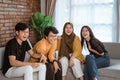 Group of Asian young people sitting together on the couch laughing together Royalty Free Stock Photo