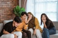 Group of Asian young people sitting together on the couch laughing together Royalty Free Stock Photo