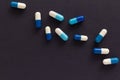 Group of assorted white and blue tablets. Black background. Line