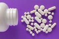 Group of assorted white tablets. Capsules spilling out of white Royalty Free Stock Photo