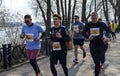 Group of athletes running along a riverside path in a marathon event Royalty Free Stock Photo