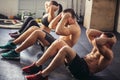 Group of athletic adult men and women performing sit up exercises Royalty Free Stock Photo