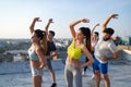Group of happy fit young people friends in sportswear doing exercises . Sport outdoors Royalty Free Stock Photo