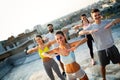 Group of happy fit young people friends in sportswear doing exercises . Sport outdoors Royalty Free Stock Photo