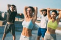 Group of happy fit young people friends in sportswear doing exercises . Sport outdoors Royalty Free Stock Photo