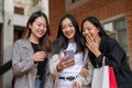 Group of attractive, fun Asian girls are enjoy looking at something interesting online on her phone Royalty Free Stock Photo