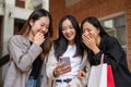 Group of attractive, fun Asian girls are enjoy looking at something interesting online on her phone Royalty Free Stock Photo