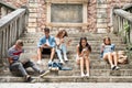 Teenage students with gadgets outside on stone steps. Royalty Free Stock Photo