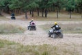 A group ATV ride through an autumn forest. People ride one after