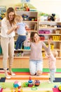 Group of babies toddlers playing with colorful educational toys together with mothers in nursery room Royalty Free Stock Photo