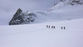 A group of backcountry skiers hike and climb to a remote moutain peak in Switzerland