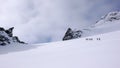 A group of backcountry skiers hike and climb to a remote moutain peak in Switzerland