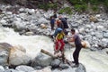 Group of backpacker tourists crossing river
