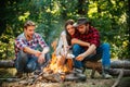 Group of backpackers relaxing near campfire. Friends spend leisure weekend forest nature background. Tourists relaxing Royalty Free Stock Photo