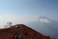 A group of backpackers standing at the top of volcano