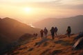 A group of backpackers walking through the mountains at sunset.