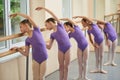 Group of ballerinas training at ballet barre.