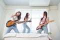 Group of Asian women playing electric guitar and electric bass and singing Royalty Free Stock Photo