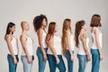 Group of beautiful diverse young women wearing white shirt and denim jeans looking aside while posing, standing isolated Royalty Free Stock Photo