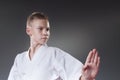 Handsome male karate player posing with on the gray background. Celebrating 1st place