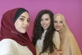 group of beautiful muslim women two of them in fashionable dress with hijab using mobile phone while taking selfie Royalty Free Stock Photo