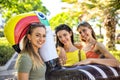 Group of beautiful women portrait on summer vacation holiday carrying inflatable toucan mattress on the street having fun together Royalty Free Stock Photo