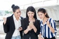 group of beautiful young women friends using a smart phone and laughing outdoors .three girl exciting business online Royalty Free Stock Photo