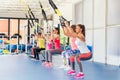 Group of beautiful young women working out on TRX. Royalty Free Stock Photo