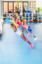 Group of beautiful young women working out on TRX. Royalty Free Stock Photo