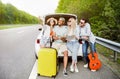 Group of best friends checking map during road trip, sitting in car trunk, taking selfie on their journey. Hitchhiking Royalty Free Stock Photo