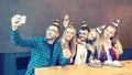 Group of best friends with festive cap taking selfie at birthday party celebrating with cake and champagne Royalty Free Stock Photo